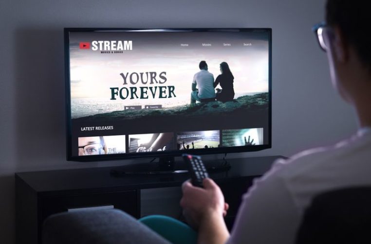 man streaming movies online on TV