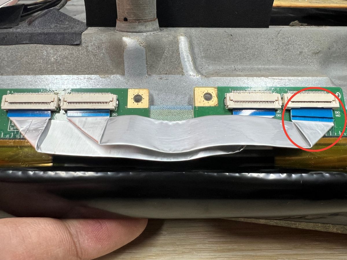 One of the ribbon cable at inside the TV is loosen and being highlighted with a red circle