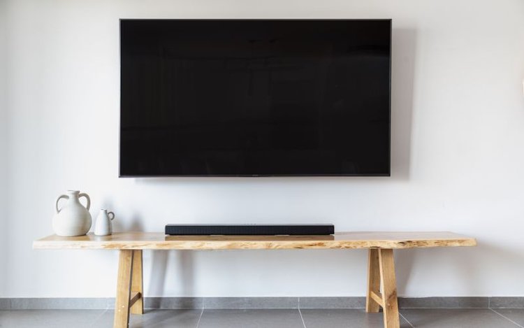 TV mounted on the wall above the wooden table