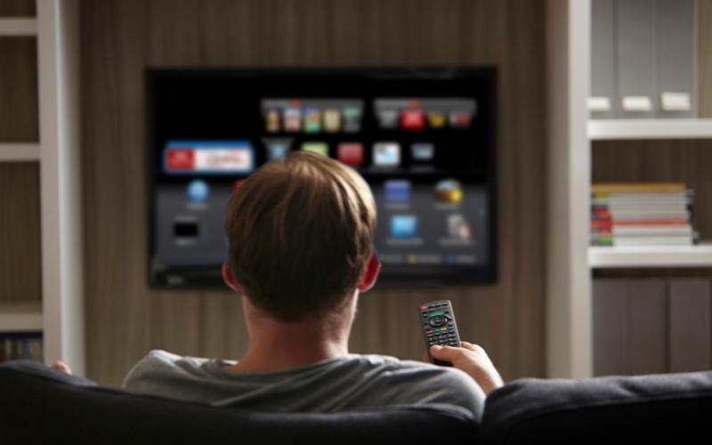 a man selects an app to watch TV