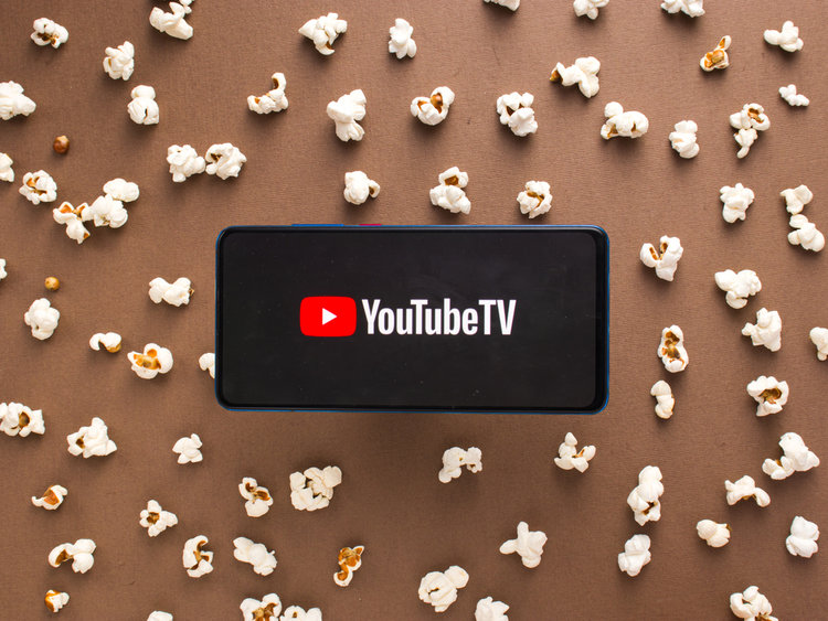 a phone showing youtube tv with corns on the background table