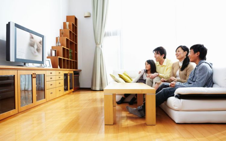 an Asian family watching TV in a living room