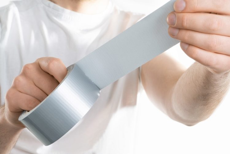 close up image of a man holding adhesive tape