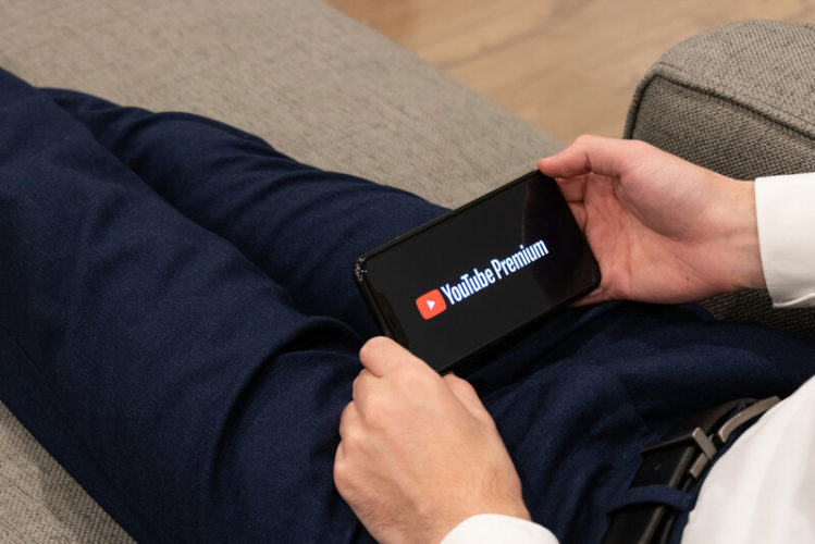 man holding a phone with YouTube Premium logo on the phone screen