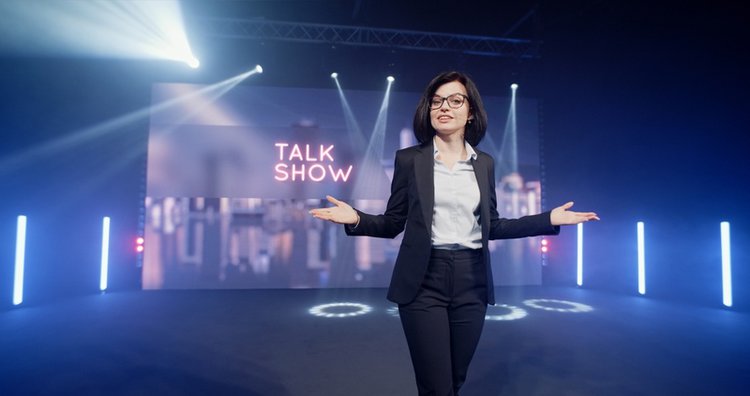 woman presenter in suit and glasses in a talk show on broadcast TV