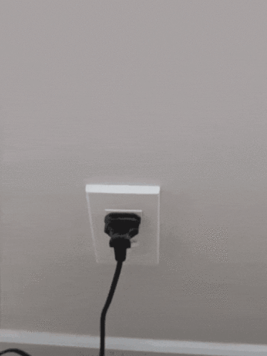 A hand unplugging the power adapter from the power outlet