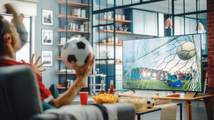 A man watching football on TV in the living room