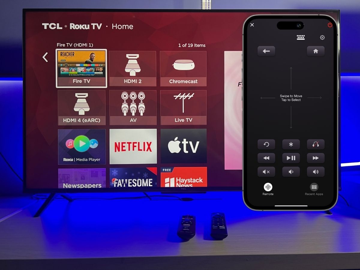 An iPhone is using the Roku remote app to control the TCL Roku TV