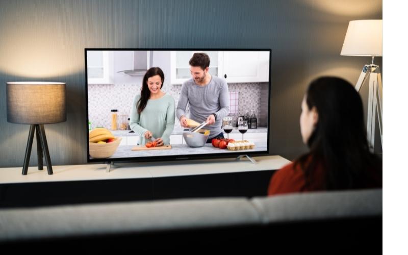 a woman is watching TV about cooking