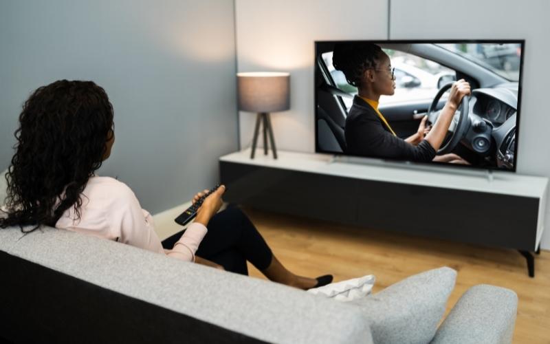 a woman is watching movie on TV