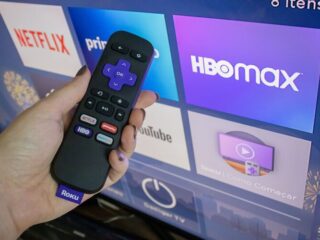 Roku remote in front of a TV