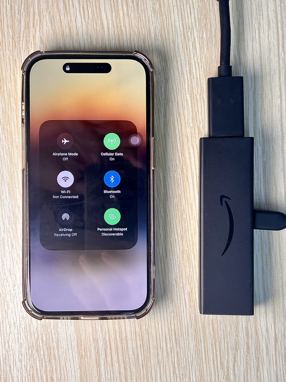 an iphone's hotspot is enabled next to a fire tv stick