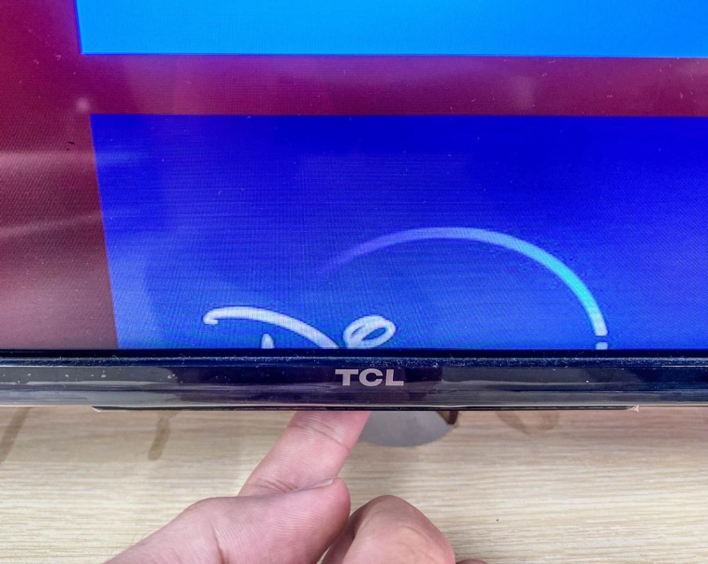 press the control button on the bottom panel of the TCL Roku TV