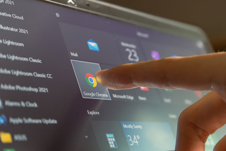 touching Google Chrome icon on computer screen