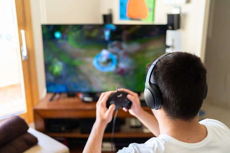 young man wearing headphone and playing game on TV