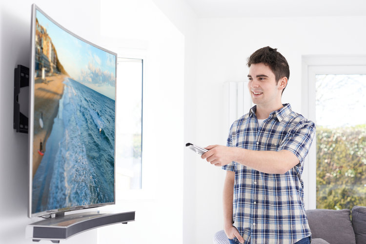 A man watching a curve TV