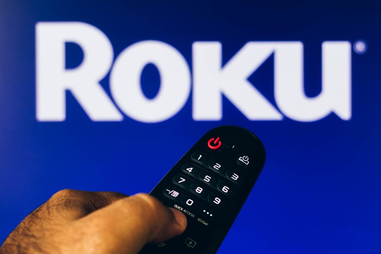 A remote with Roku TV in the background