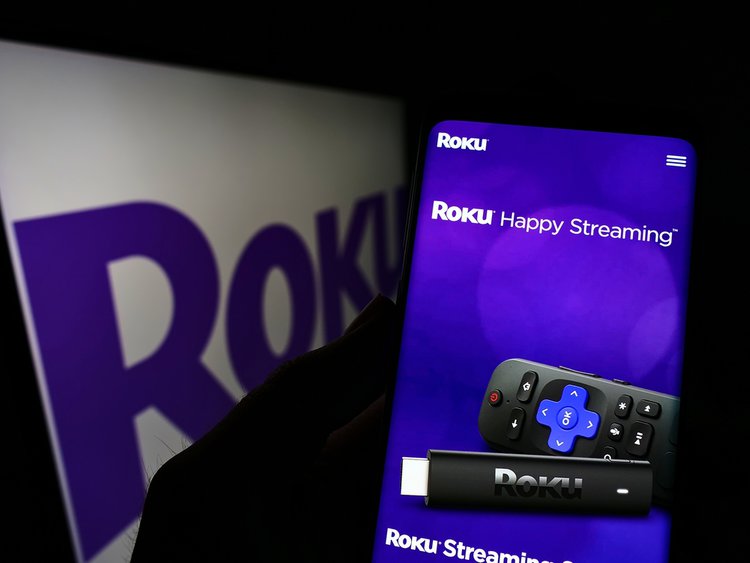 Roku streaming stick next to a TV
