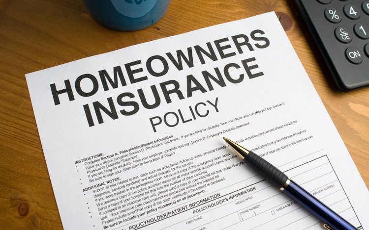 a Homeowners Insurance Policy on table with a pen