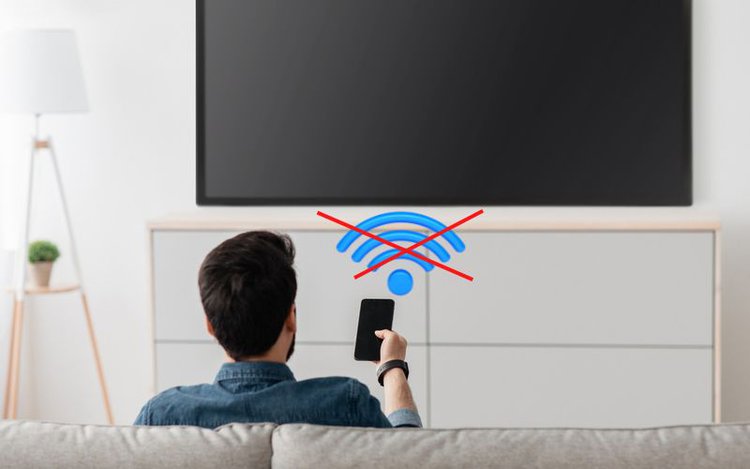 a man pointing his phone towards a TV without wifi connection