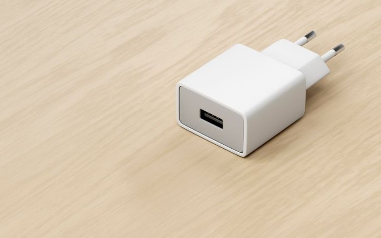 a white USB power adapter on wooden surface