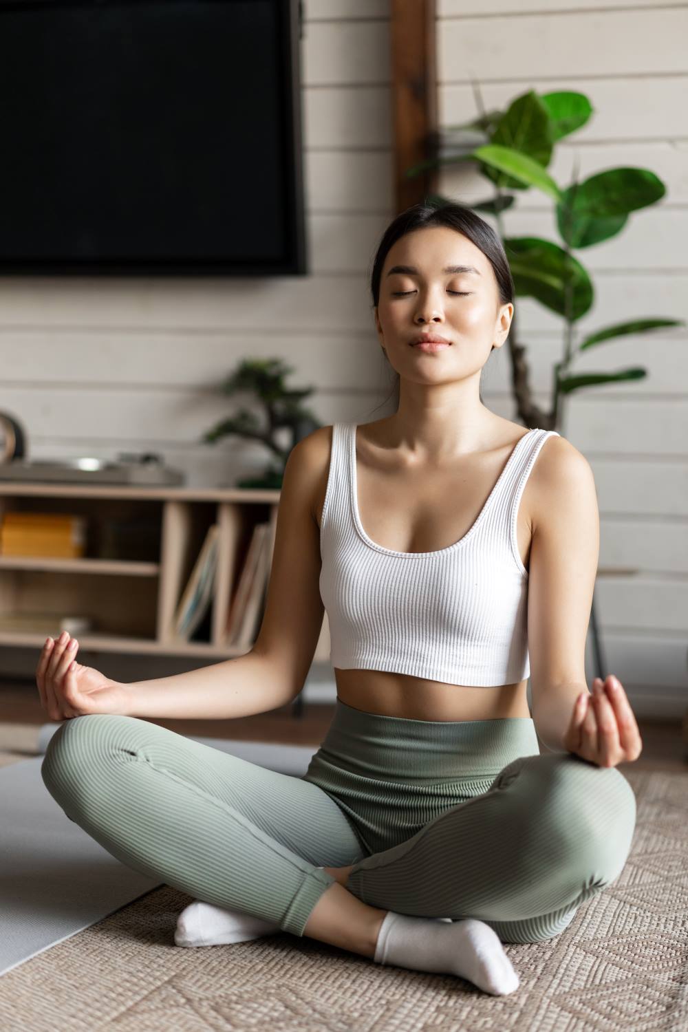 a women is meditating in front of a TV
