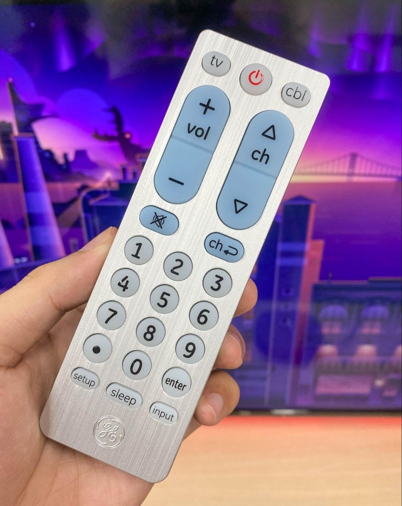 holding a GE universal remote