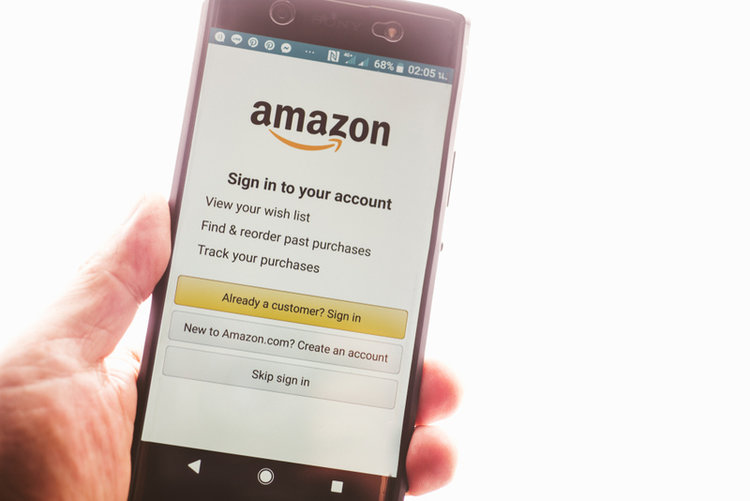 man holding a phone screen with Amazon account sign-in page