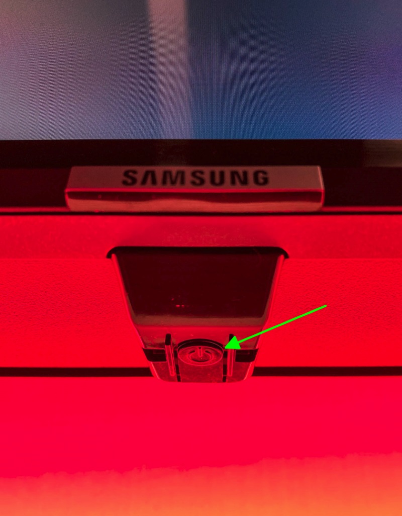 pointing to the panel control button of the Samsung TV