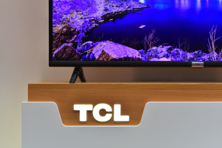 TV on a wooden stand with TCL logo in close-up view