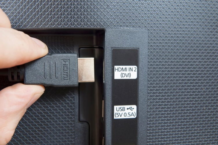 a man plugging HDMI cable into HDMI IN port