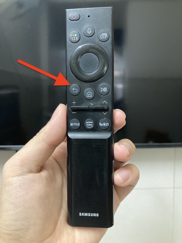 a red arrow point at Exit button on Samsung TV remote