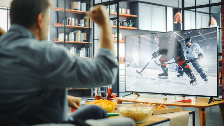 man watching ice hockey on TV at home