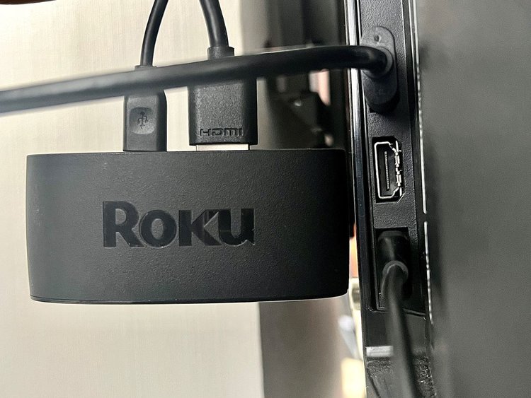 a roku express 4k+ is plugged into a tv and next to the tv ports