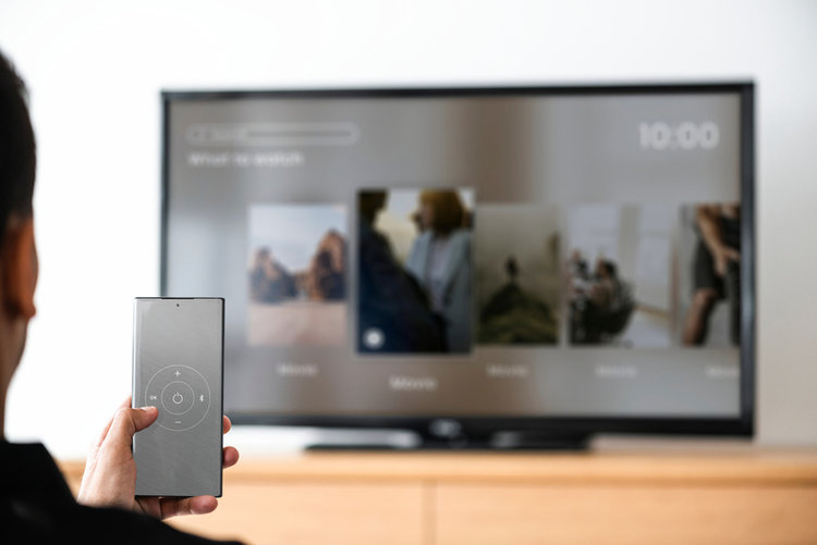 man using a smartphone to control a TV