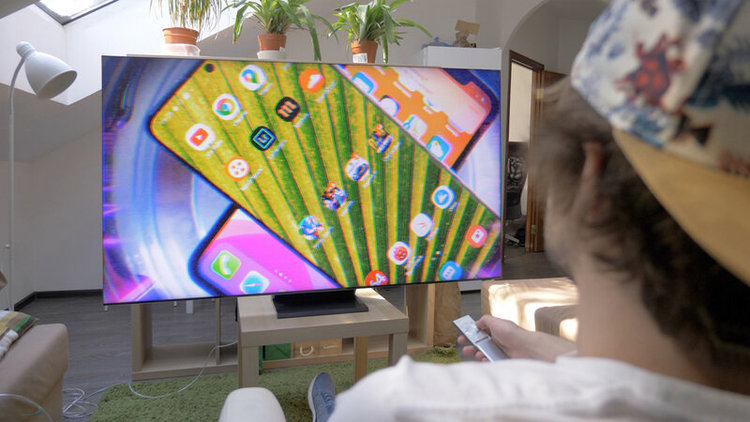 man watching TV with smartphones on the TV screen