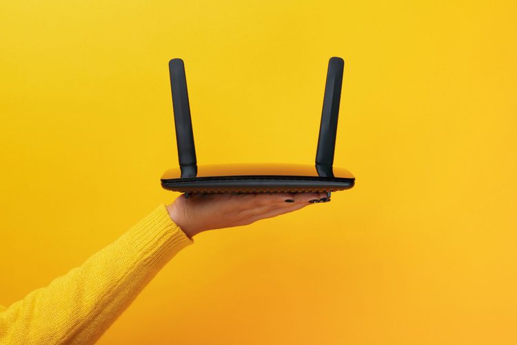 A black wifi router in yellow background