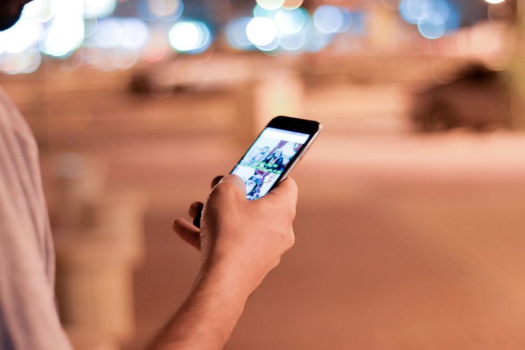 A man holding a smartphone on the street