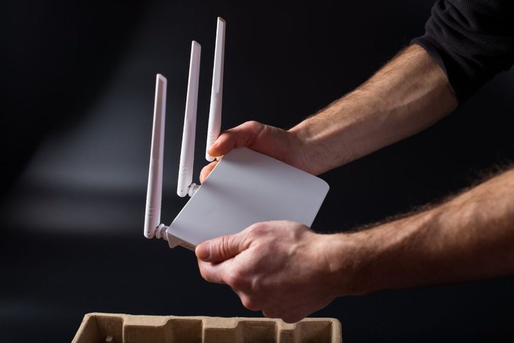 A man holding a white wifi router