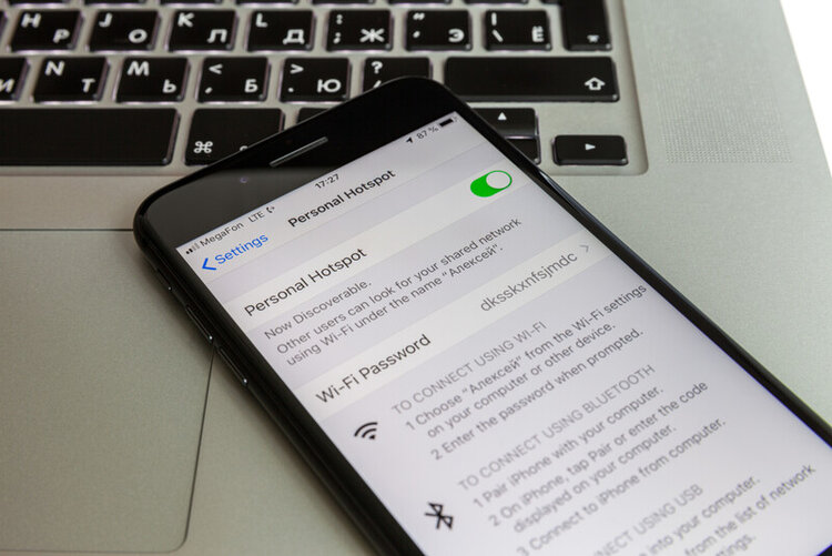 an iPhone on the MacBook keyboard with personal hotspot on