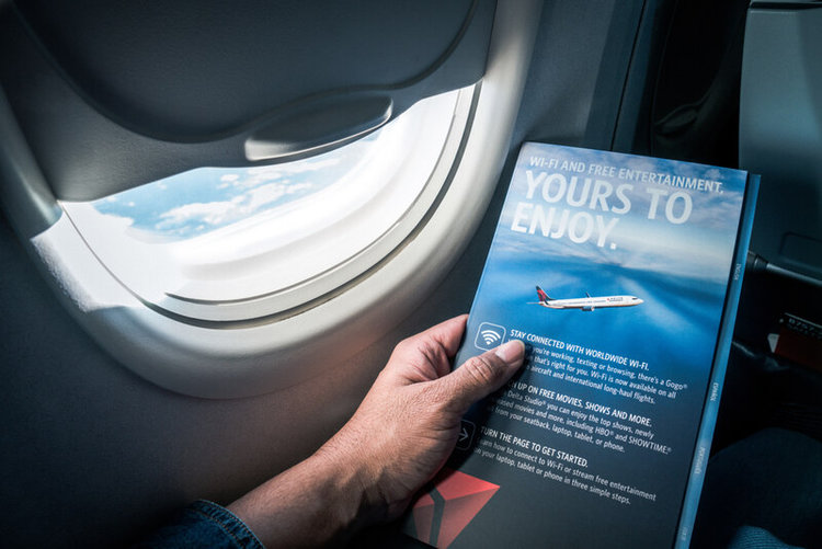 man holding a flyer about services on the plane