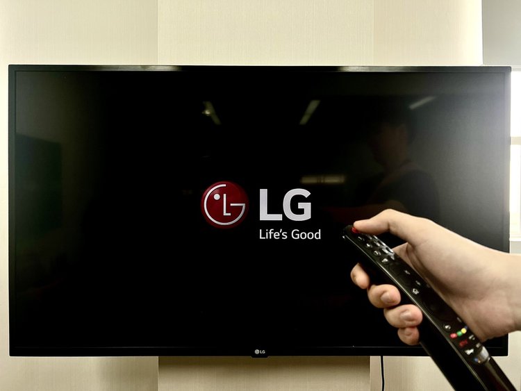 man using remote to turn off a LG TV