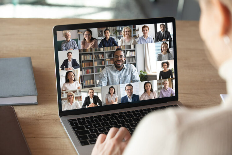 woman having video call with colleaguaes on laptop