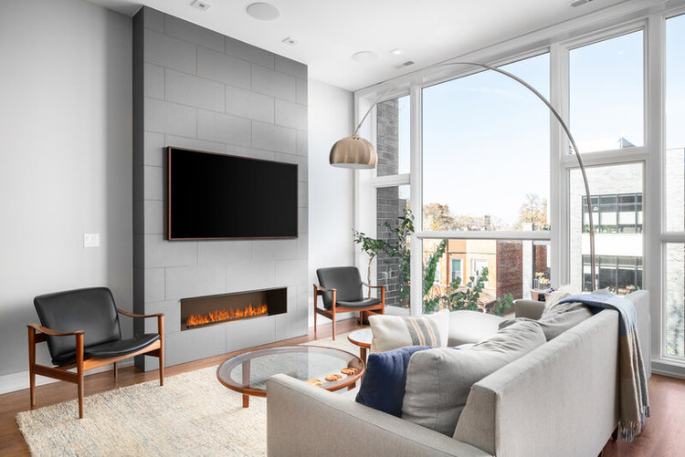 a black TV above the electric fireplace in the modern living room