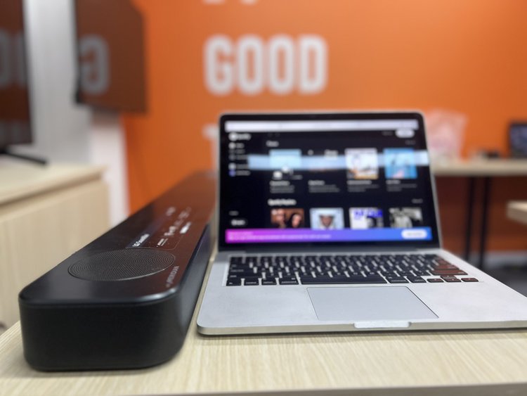 a black soundbar and laptop on a table