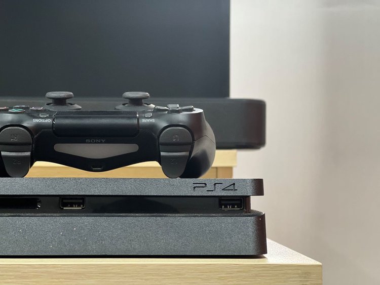 a ps4 and the controller above it