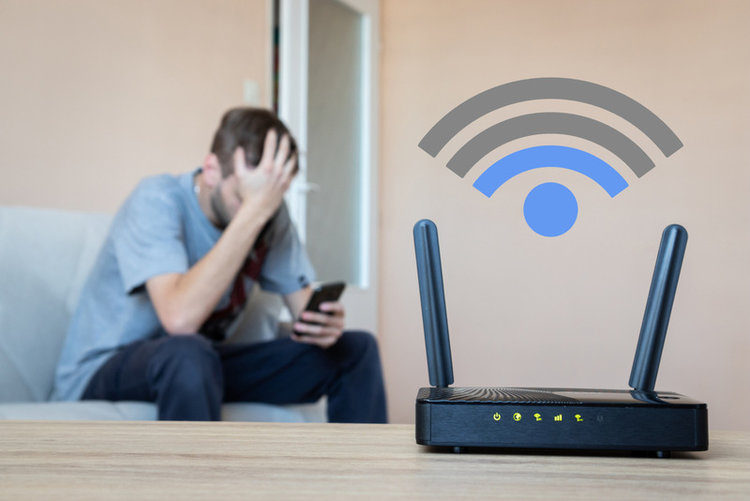 a router with weak signal and a sad man using his phone in the background