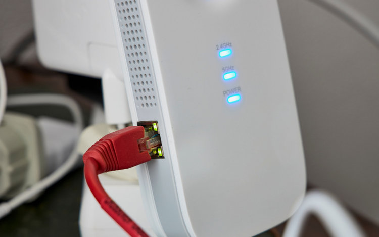 a white dual-band wifi router supporting 5 GHz