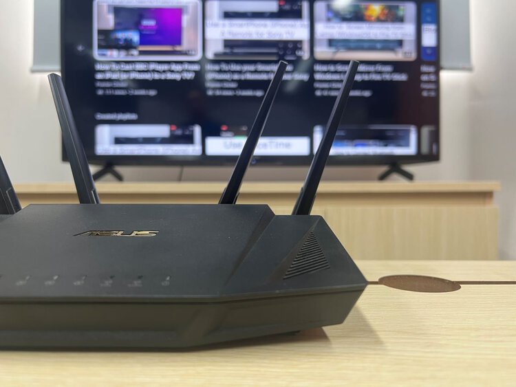 asus router on a table with a sony tv in the background