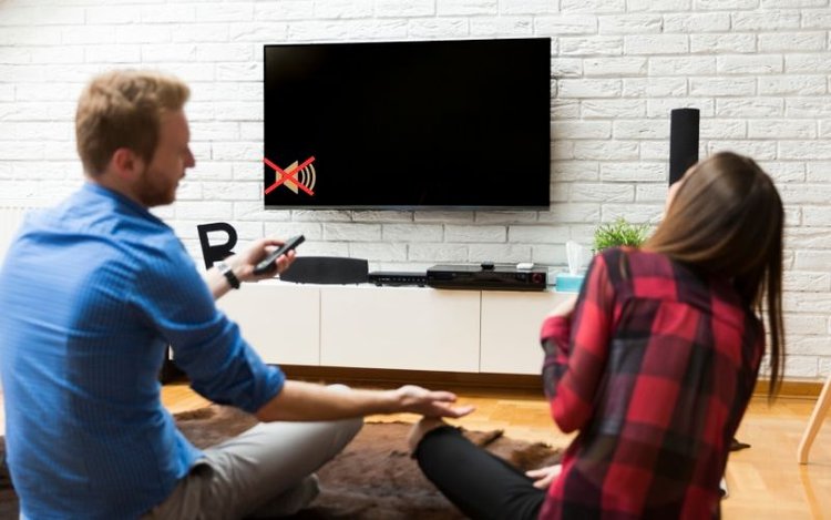 friends watching TV in the living room with no sound icon on TV screen